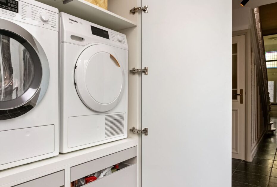 Wasmachinekast op maat, maatwerk wasmachinekast, maatwerk bijkeukenkast, bijkeukenkasten op maat, Moderne keuken Oosterhout, keukenstudio Oosterhout, keuken op maat Oosterhout, Moderne keuken Breda, keukenstudio Breda, keuken op maat Breda, composiet werkblad, hoekopstelling, Geïntegreerde Bora kookplaat met afzuiging, rvs vlakinbouw spoelbak, Gelakte fronten, push-to-open, Tip-On, wasmachinekast op maat, wasmachine op hoogte.